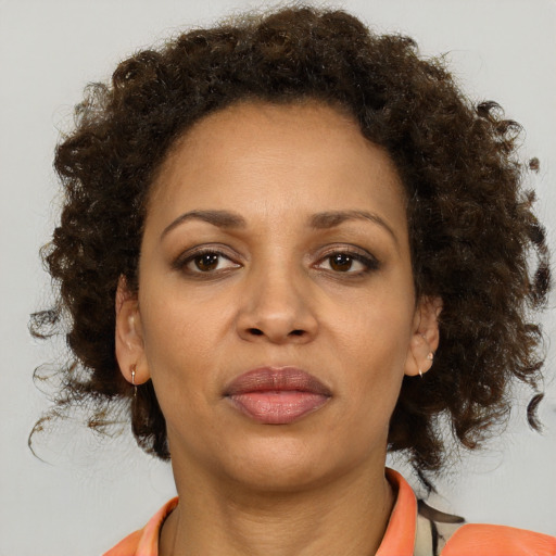 Joyful black adult female with medium  brown hair and brown eyes