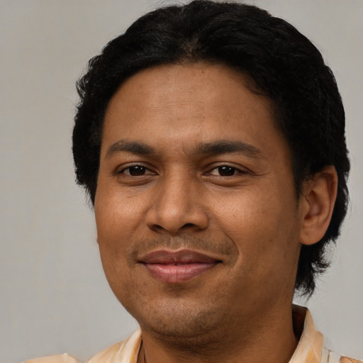 Joyful latino adult male with short  black hair and brown eyes