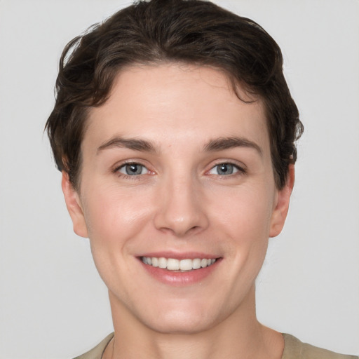 Joyful white young-adult female with short  brown hair and grey eyes