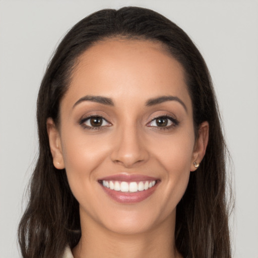 Joyful latino young-adult female with long  brown hair and brown eyes