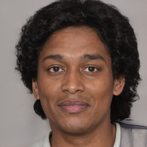 Joyful black adult male with short  brown hair and brown eyes