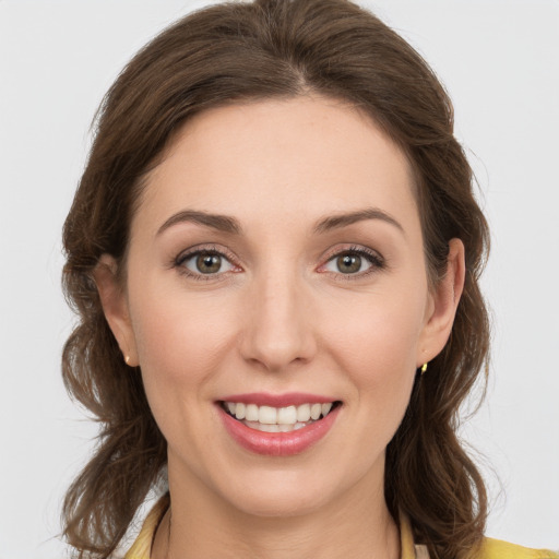 Joyful white young-adult female with medium  brown hair and green eyes