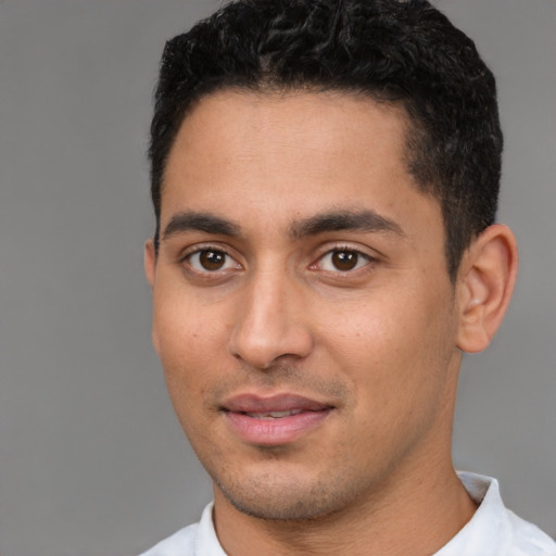 Joyful latino young-adult male with short  black hair and brown eyes