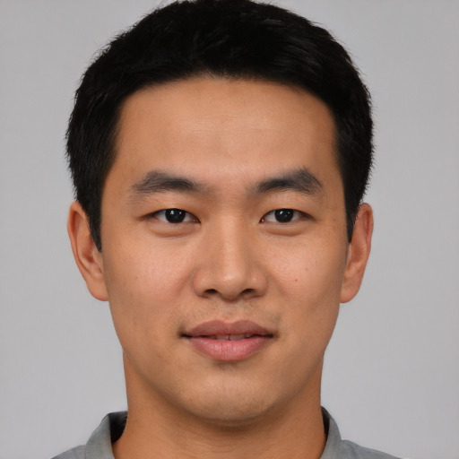 Joyful asian young-adult male with short  black hair and brown eyes