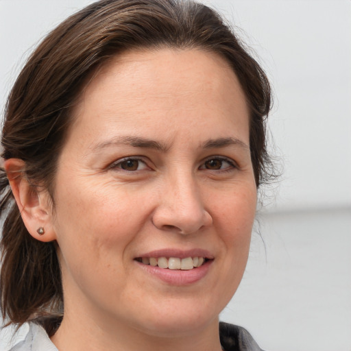 Joyful white adult female with medium  brown hair and brown eyes