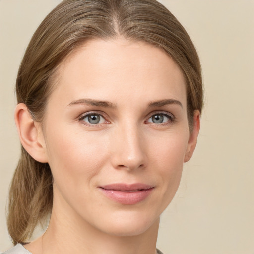 Joyful white young-adult female with medium  brown hair and grey eyes