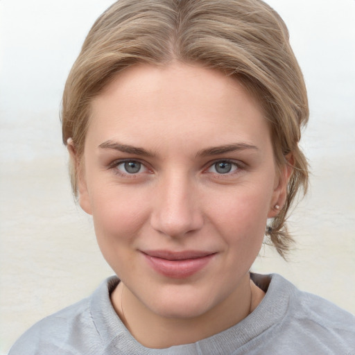 Joyful white young-adult female with short  brown hair and blue eyes