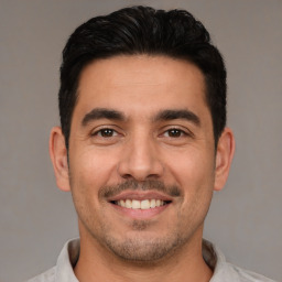 Joyful white young-adult male with short  black hair and brown eyes