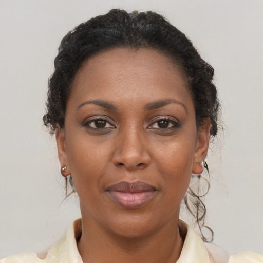 Joyful black young-adult female with long  brown hair and brown eyes