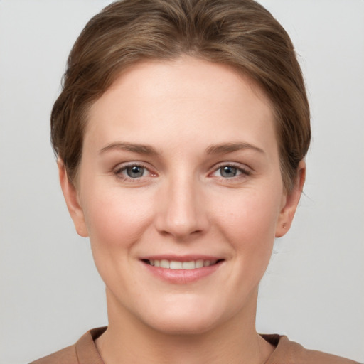 Joyful white young-adult female with short  brown hair and grey eyes