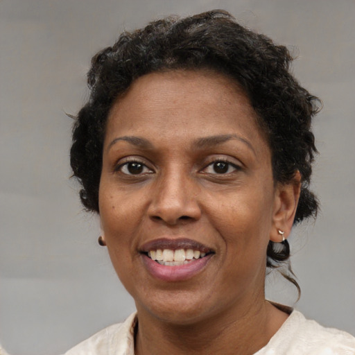 Joyful black adult female with short  brown hair and brown eyes