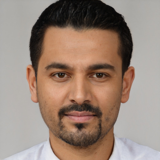 Joyful latino young-adult male with short  black hair and brown eyes