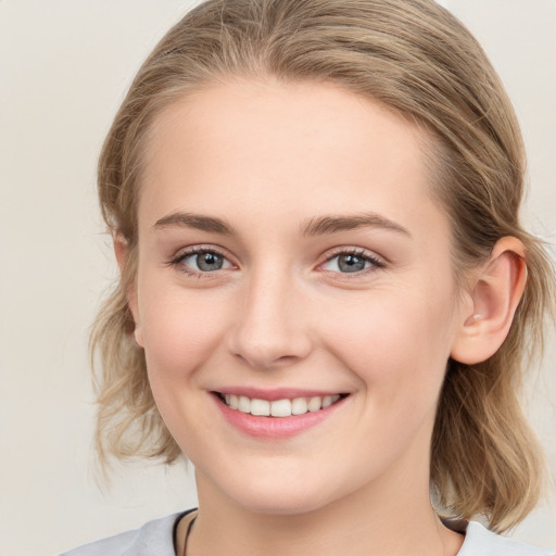 Joyful white young-adult female with medium  brown hair and blue eyes