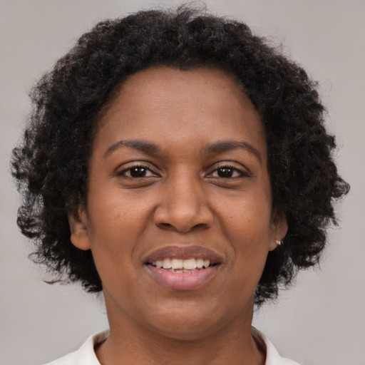 Joyful black young-adult female with short  brown hair and brown eyes