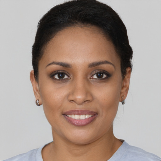 Joyful black young-adult female with short  brown hair and brown eyes