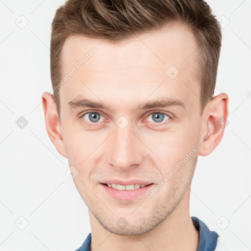 Joyful white young-adult male with short  brown hair and grey eyes