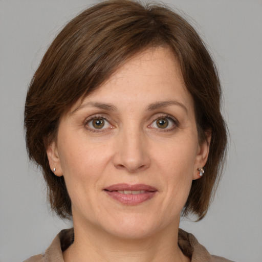 Joyful white adult female with medium  brown hair and grey eyes