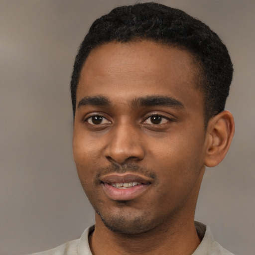 Joyful black young-adult male with short  black hair and brown eyes