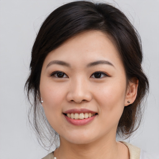 Joyful asian young-adult female with medium  brown hair and brown eyes
