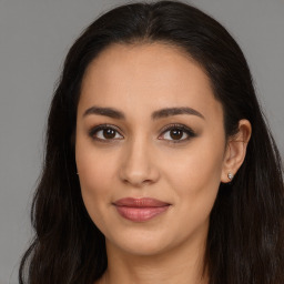 Joyful latino young-adult female with long  brown hair and brown eyes