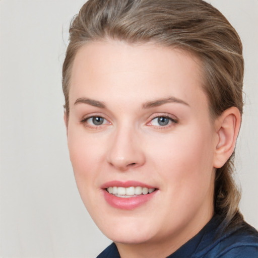 Joyful white young-adult female with short  brown hair and blue eyes