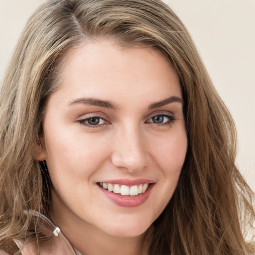 Joyful white young-adult female with long  brown hair and green eyes