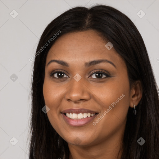 Joyful black young-adult female with long  brown hair and brown eyes