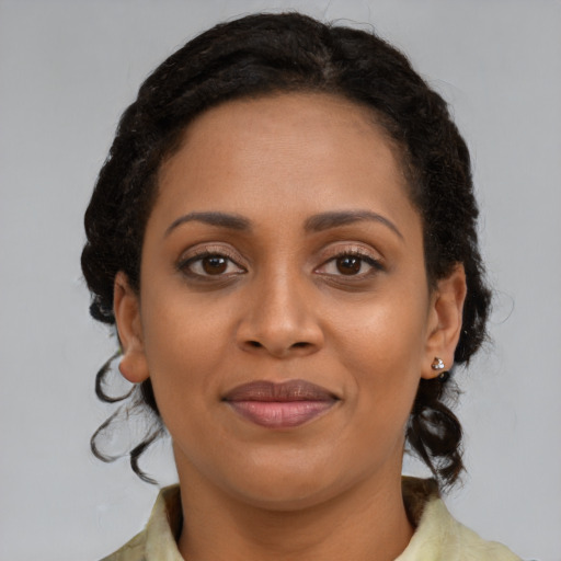 Joyful black young-adult female with medium  brown hair and brown eyes