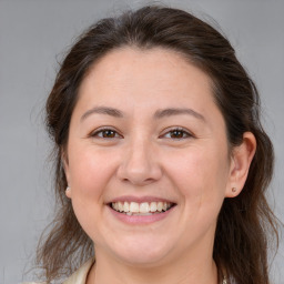 Joyful white adult female with medium  brown hair and brown eyes