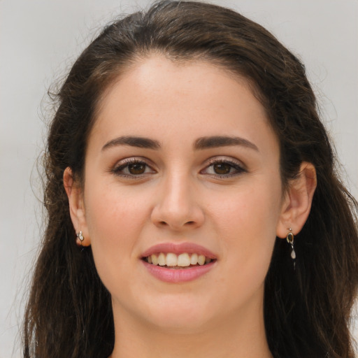 Joyful white young-adult female with long  brown hair and brown eyes