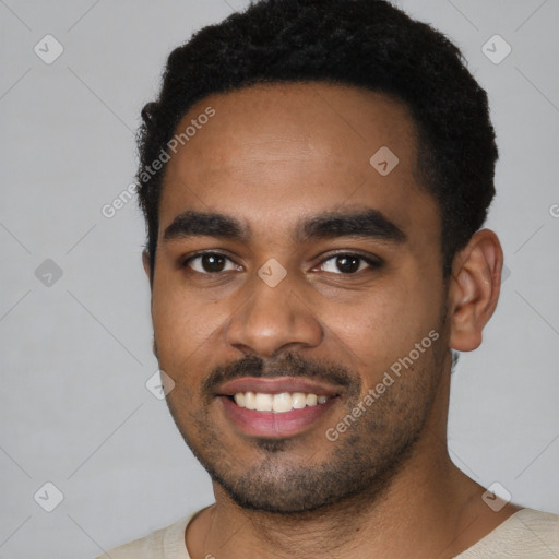 Joyful black young-adult male with short  black hair and brown eyes