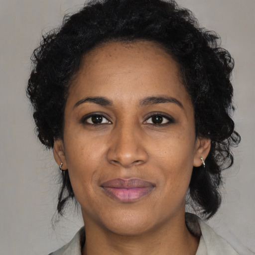 Joyful black adult female with long  black hair and brown eyes