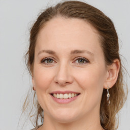 Joyful white young-adult female with medium  brown hair and green eyes