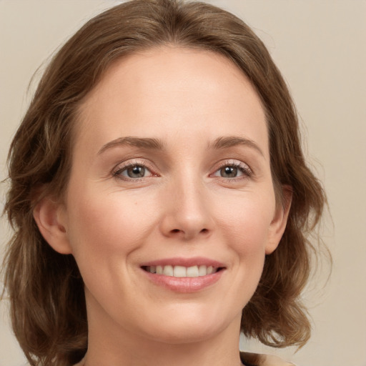 Joyful white young-adult female with medium  brown hair and green eyes