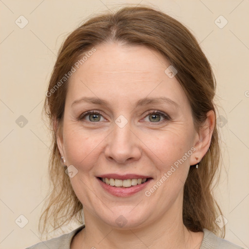 Joyful white adult female with medium  brown hair and grey eyes