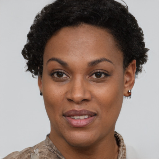 Joyful black young-adult female with short  brown hair and brown eyes