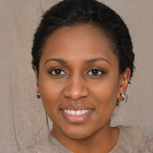 Joyful black young-adult female with short  black hair and brown eyes
