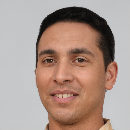 Joyful white young-adult male with short  black hair and brown eyes