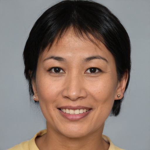 Joyful asian young-adult female with medium  brown hair and brown eyes
