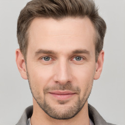 Joyful white young-adult male with short  brown hair and grey eyes