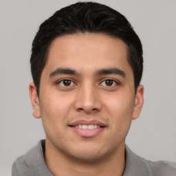 Joyful latino young-adult male with short  brown hair and brown eyes