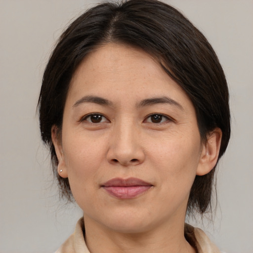 Joyful asian adult female with medium  brown hair and brown eyes