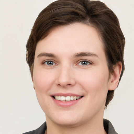 Joyful white young-adult female with short  brown hair and grey eyes