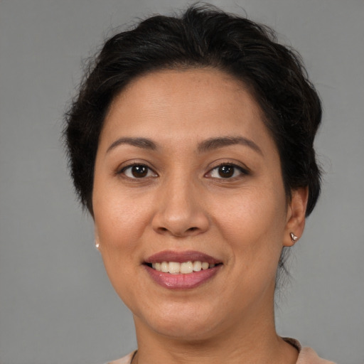 Joyful latino adult female with short  brown hair and brown eyes
