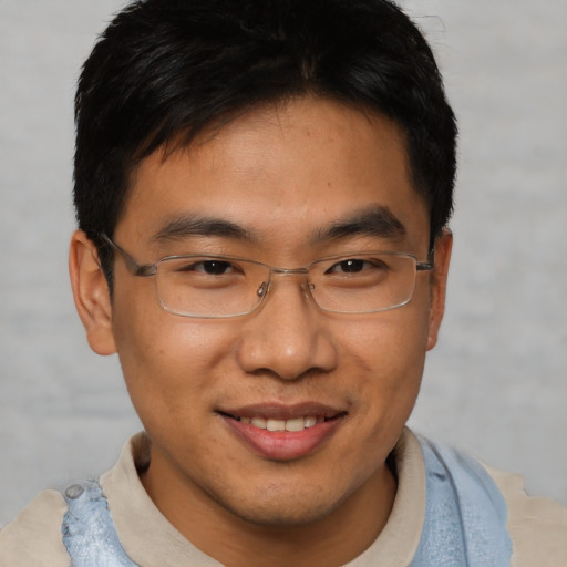 Joyful asian young-adult male with short  brown hair and brown eyes