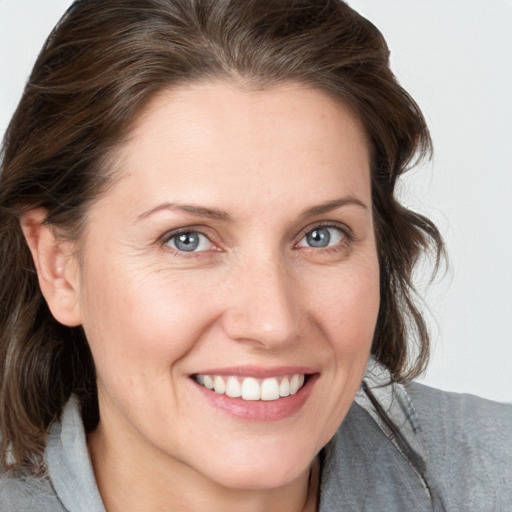 Joyful white adult female with medium  brown hair and grey eyes