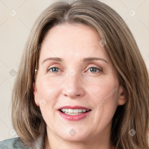 Joyful white adult female with medium  brown hair and blue eyes