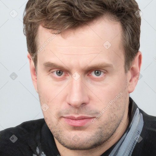 Joyful white adult male with short  brown hair and grey eyes