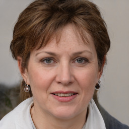 Joyful white adult female with medium  brown hair and blue eyes