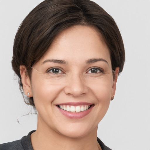 Joyful white young-adult female with short  brown hair and grey eyes